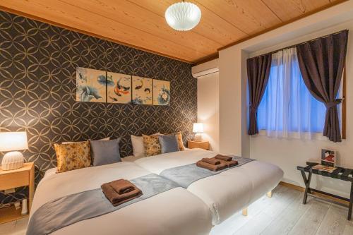a bedroom with a large bed with two towels on it at IROHA STAY HANEDA - Family-Friendly Home Stay near Haneda with Great Access to Tokyo & Yokohama in Tokyo