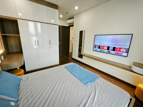 a bedroom with a bed and a flat screen tv at Ấm cúng, hiện đại, tiện nghi 3! in Hai Phong