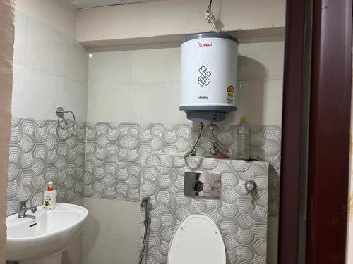 a bathroom with a toilet and a water tank on the wall at Couple Love Condos 1BHK in Zirakpur