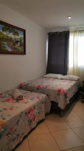 a bedroom with two beds and a picture on the wall at VillaLore piscina exclusiva BBQ AC max 11 personas 5min playas in Carpintero