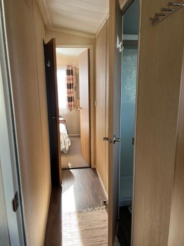 a hallway with a door open to a room at Flower Bay in Prestatyn