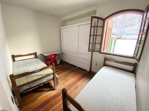 una habitación con dos camas y una ventana en República Favela, en Ouro Preto