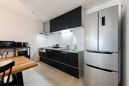a kitchen with a stainless steel refrigerator and a table at The wisteria in Sapporo