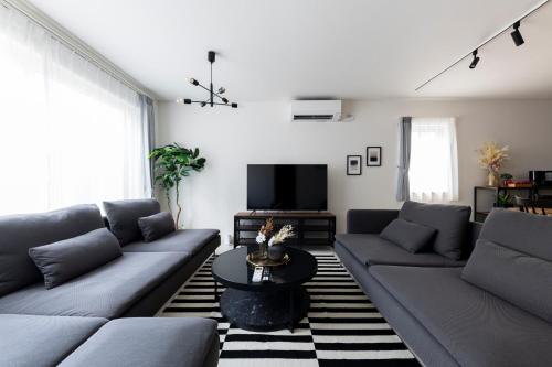 a living room with couches and a tv at The wisteria in Sapporo