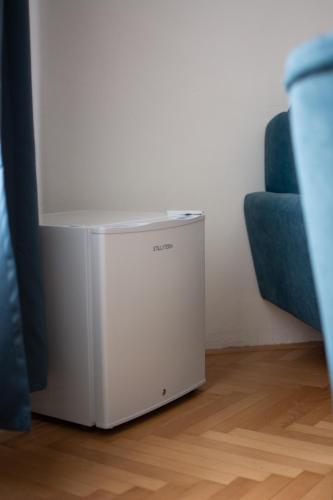 a white refrigerator in a room with a blue couch at Hostel Moravia Ostrava in Ostrava
