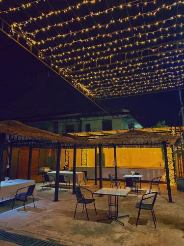 a patio with tables and chairs and lights at Venn Hostel in Vientiane