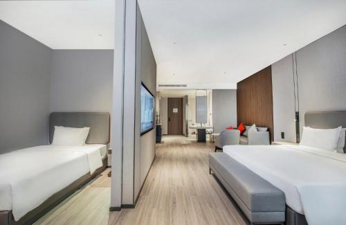 a hotel room with two beds and a living room at Holiday Inn Express Yinchuan Lanxi Valley Plaza by IHG in Yinchuan