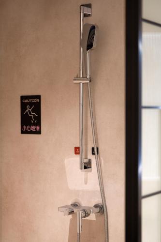 a shower head in a bathroom with a sink at Xiamen Zhongshan Road Pedestrian Street Qulistar Hotel in Xiamen