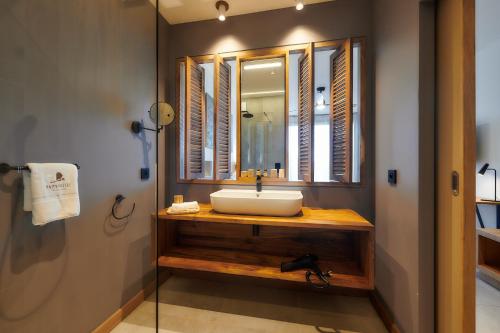 a bathroom with a sink and a mirror at Papangue Hôtel & Spa in Étang-Salé