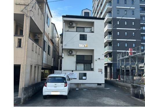 a white car parked in front of a building at エスポアール新町Ⅵ(101) in Hanabatachō