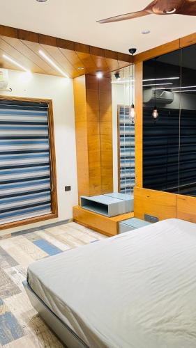a bedroom with a bed and a large window at Nisarg’s stays in Ahmedabad