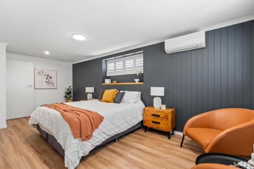 a bedroom with a bed and a chair at Shades Of Summer 50 Park Street in Evans Head
