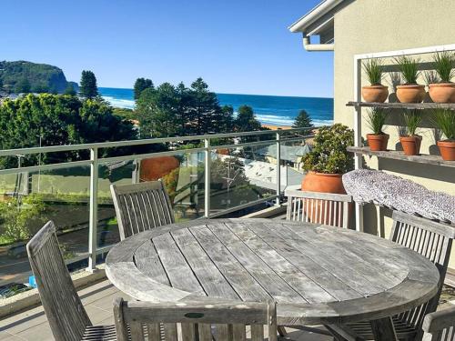 a wooden table and chairs on a balcony at Penthouse - 4 Bedrooms - Unit 33 at Avoca Palms Resort in Avoca Beach