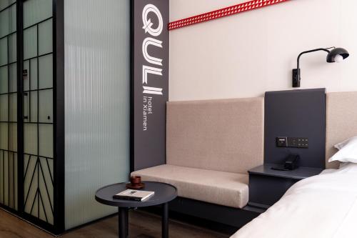 a hotel room with a bed and a couch and a table at Xiamen Zhongshan Road Pedestrian Street Qulistar Hotel in Xiamen