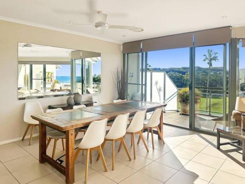 a dining room with a large wooden table and chairs at Penthouse - 4 Bedrooms - Unit 33 at Avoca Palms Resort in Avoca Beach