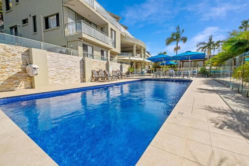 a swimming pool in front of a building at Penthouse - 4 Bedrooms - Unit 33 at Avoca Palms Resort in Avoca Beach