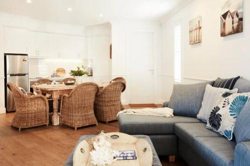 a living room with a couch and a table at Beach Front House Outdoor Hot Tub Sauna in Patonga