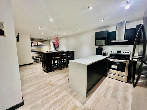 a kitchen with black and white appliances and a table at Luxury Apt Near Airport in Guatemala