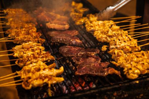 a bunch of food cooking on a grill at The ANMON Resort Bintan in Lagoi