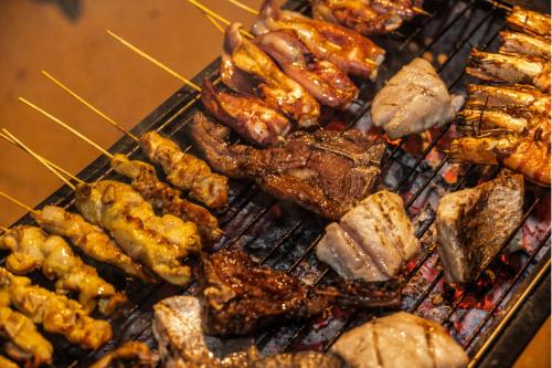 a bunch of different types of food on a grill at The ANMON Resort Bintan in Lagoi
