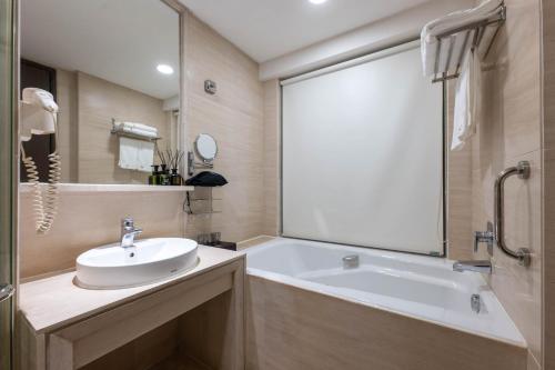 a bathroom with a sink and a bath tub at Yueta E-Sports Hotel-10min to Guangzhou East Railway Station&Entrance Exit J of Line 3 in Guangzhou