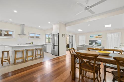 a kitchen and dining room with a table and chairs at Sunnyside 15B Baldwin St South West Rocks - Full Linen Provided in South West Rocks