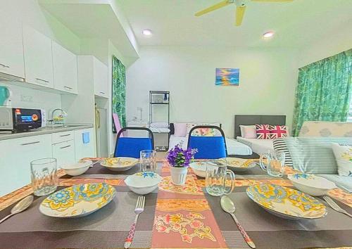a dining room table with plates and utensils on it at Lovely Cybersquare Ensuite with Skyline View #CS6 in Cyberjaya