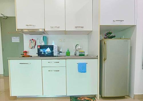 a kitchen with white cabinets and a refrigerator at Lovely Cybersquare Ensuite with Skyline View #CS6 in Cyberjaya