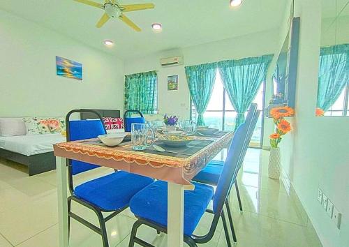 a dining room with a table and blue chairs at Lovely Cybersquare Ensuite with Skyline View #CS6 in Cyberjaya
