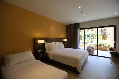 a hotel room with two beds and a balcony at Pamookkoo in Kata Beach