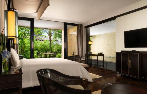 a bedroom with a large bed and a television at The Apurva Kempinski Bali in Nusa Dua