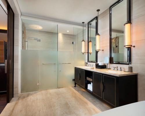 a bathroom with a glass shower and a sink at The Apurva Kempinski Bali in Nusa Dua