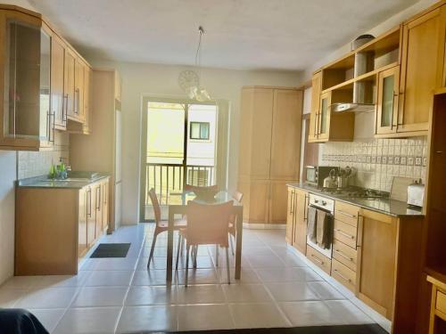 a kitchen with a table and chairs in it at Spacious 3 bedroom in Swatar - Birkirkara in Birkirkara