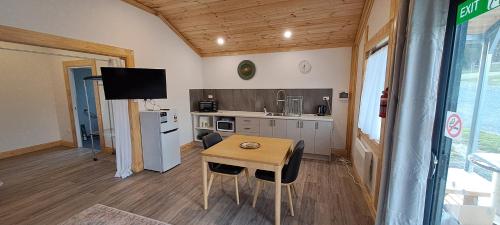 a kitchen with a wooden table and a small table with chairs at Meander Country Cabins in Meander