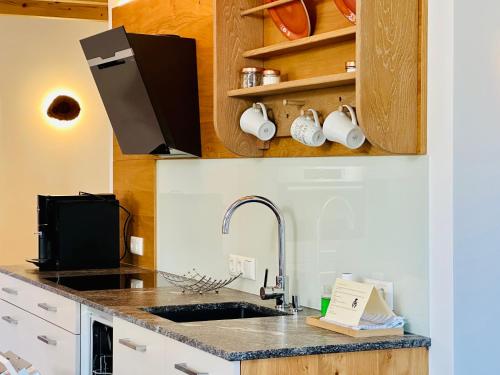 a kitchen with a sink and a counter top at Brunnwirt ESSEN & WOHNEN in Fuschl am See