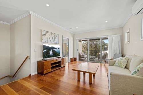 a living room with a couch and a tv at Sunnyside 15B Baldwin St South West Rocks - Full Linen Provided in South West Rocks