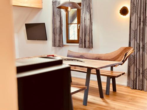 a living room with a table and a chair at Brunnwirt ESSEN & WOHNEN in Fuschl am See