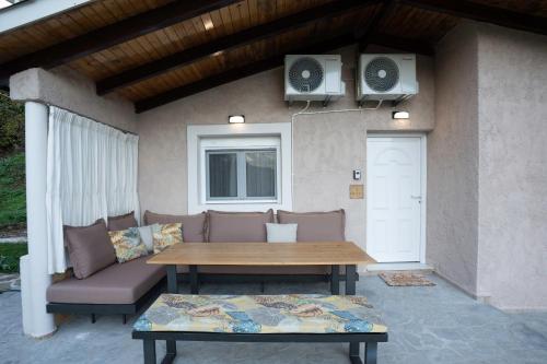 a patio with a table and a couch and speakers at PLATS Traditional Living in Dáfni