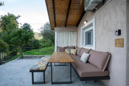 a couch and a table on a patio at PLATS Traditional Living in Dáfni