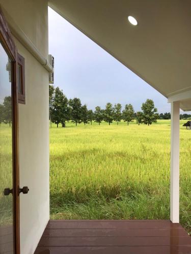 an open porch with a view of a field of grass at Tiny house homestay & cafe T1 in Ban Mai Lao Yao