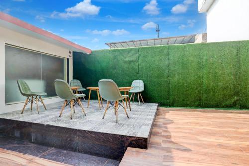 a group of chairs and a table on a patio at Staybook The Rudveda Resort - Free High Tea near Pool Area in Rāmnagar