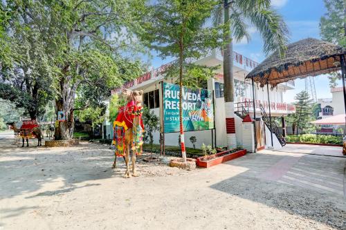 a statue of a cow in front of a building at Staybook The Rudveda Resort - Free High Tea near Pool Area in Rāmnagar