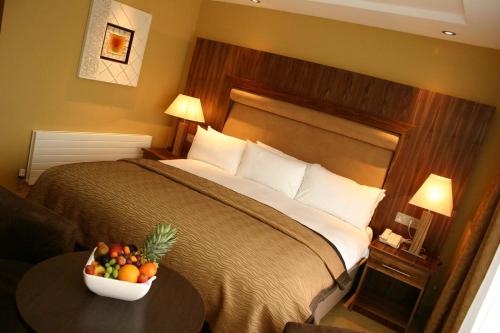 a hotel room with a bed with a bowl of fruit on a table at Annebrook House Hotel in Mullingar