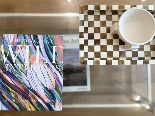 a book and a cup on a glass shelf at Modern & Quiet 1BR Apartment with Private Garden in Bondi close to the Beach in Sydney