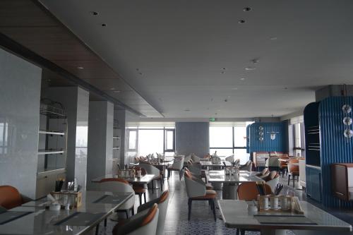 una sala da pranzo con tavoli e sedie in un ristorante di 南昌象湖格兰云天大酒店 a Taohua