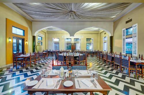 a restaurant with tables and chairs in a room at Pearl Continental Hotel, Rawalpindi in Rawalpindi