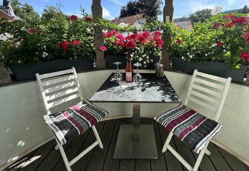 a table and two chairs on a balcony with flowers at FeWo Burgblick in Bad Blankenburg