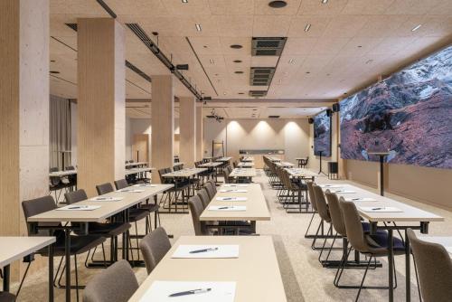 a dining room with tables and chairs and a large painting at Solo Sokos Hotel Pier 4 in Helsinki
