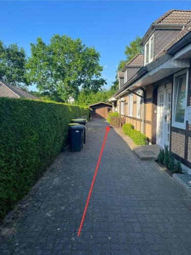 a brick sidewalk with a red line in front of a house at Ferienwohnung Sonnenschein Gartenblick in Uelzen