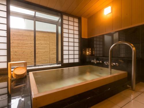 a large bath tub in a kitchen with a window at Chousenkaku Kameya in Shimo-suwa